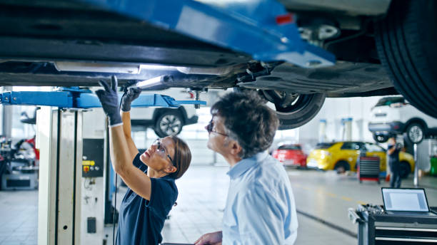 istock Female Mechanic And Manager Discussing Repairs Underneath Car At Workshop 1892164102