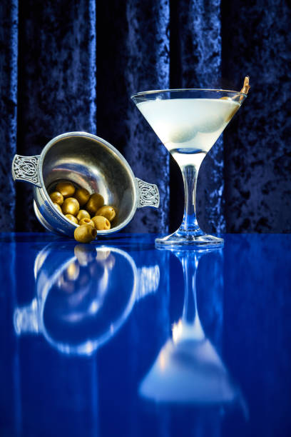 vista dal basso del cocktail margarita con olive nel piatto e come decorazione si leva in piedi sul bancone blu del bar del ristorante di lusso. - martini brand vermouth foto e immagini stock