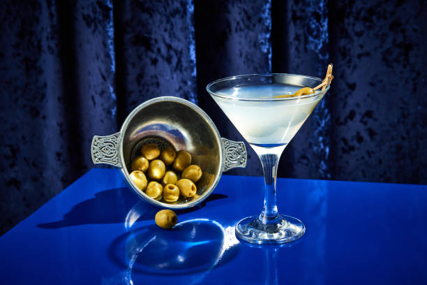 foto ravvicinata del cocktail margarita con olive nel piatto e come guarnizione servita sul bancone blu del bar del ristorante di lusso. - martini brand vermouth foto e immagini stock