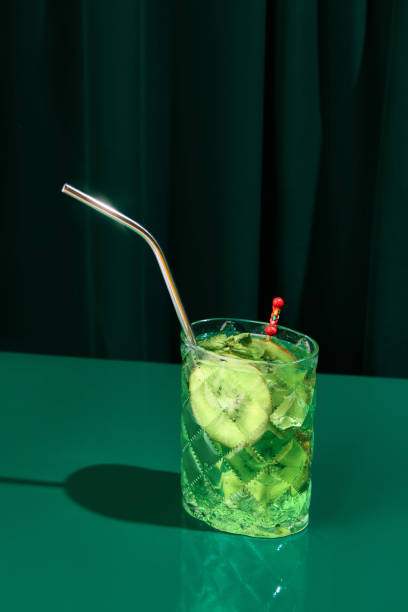 foto ravvicinata di freddo rinfrescante, mojito alcolico con kiwi con paglia servito sul bancone del bar al ristorante. concetto di atmosfera di festa. - martini brand vermouth foto e immagini stock