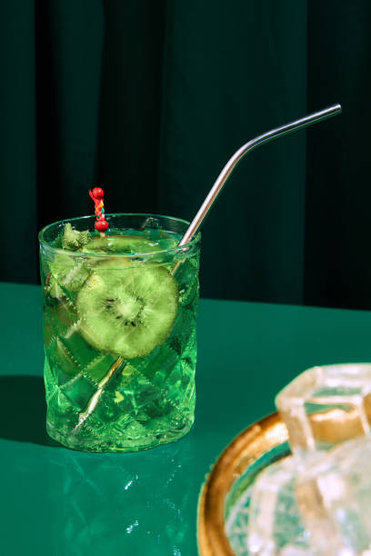 foto ravvicinata di freddo rinfrescante, alcol mojito agrodolce con kiwi con paglia servito sul bancone del bar al ristorante. - martini brand vermouth foto e immagini stock