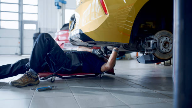 istock Male Mechanic On Creeper Working Under Car At Workshop 1892179120