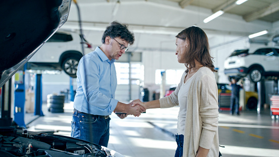 Manager Shaking Hands With A Satisfied Customer At The Auto Repair Shop,Concluding The Service With Professionalism And Client Fulfillment
