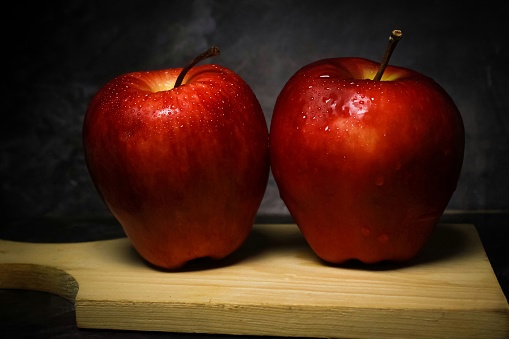 two red apples on a black background