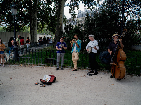 Paris, France - August 14, 2023: Street musicians perfom at a public park in Paris, France.