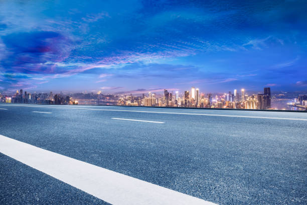 istock Empty asphalt road and city buildings skyline at night 1892246823