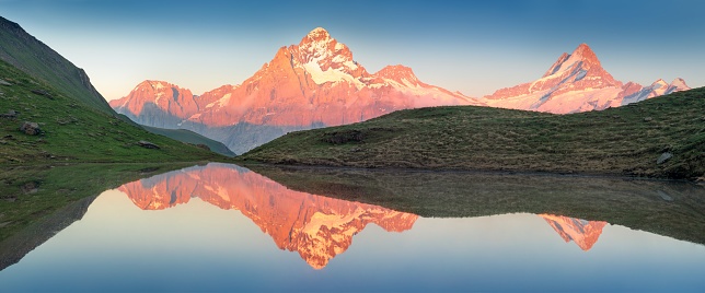 Panorama of Bachalpsee lake in Swiss Alps mountains. Snowy peaks of Wetterhorn, Mittelhorn and Rosenhorn on background. Grindelwald valley, Switzerland. Landscape photography\nBern canton, Switzerland, Europe