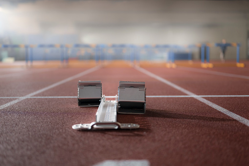 Running starting block on track in sports hall.