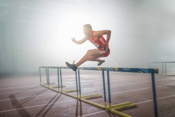 istock Athlete man jumping over hurdle 1892280400