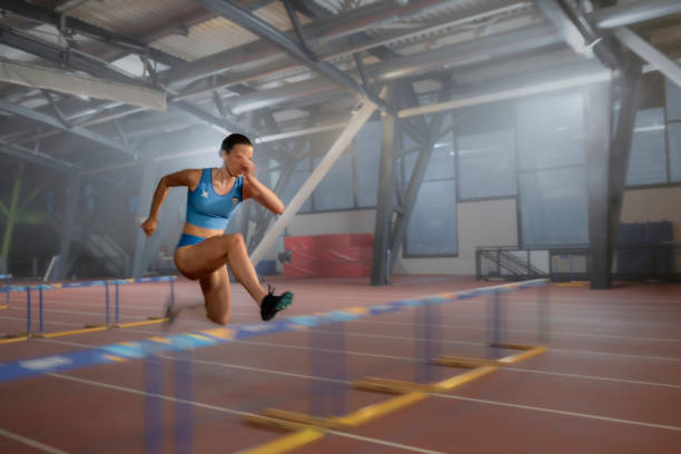 Athlete woman jumping over hurdle