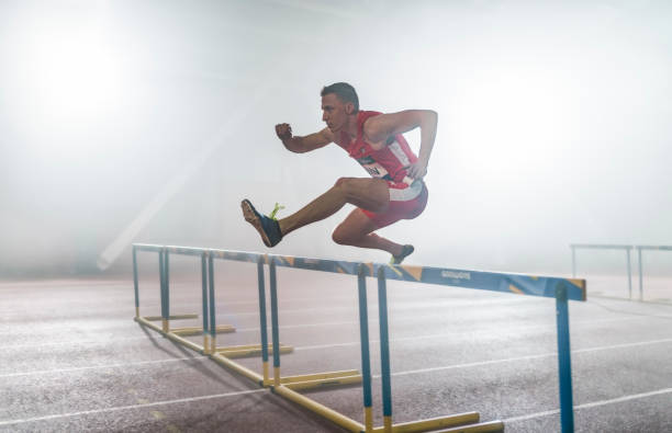 istock Athlete man jumping over hurdle 1892280414