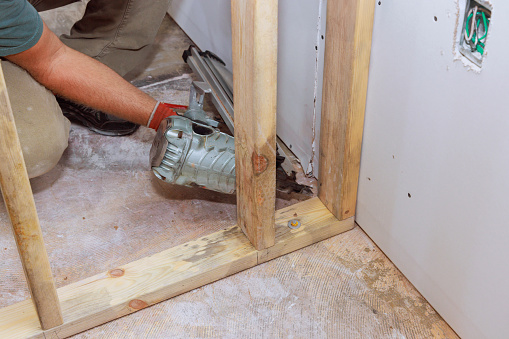 An air hammer is being used builder to nail wooden beams to housing frameworks