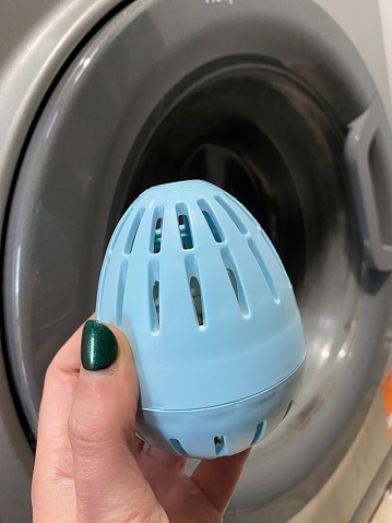 In a commitment to sustainable living, a blue eco egg, symbolizing eco-friendly laundry practices, finds its place in a washing machine. Cradled in the hand of a person with green nail varnish, the scene unfolds in a light blue kitchen, echoing a sense of environmental responsibility.

The eco egg, a testament to innovation, signifies a departure from traditional laundry detergents, offering a sustainable alternative. Its presence in the washing machine reflects a conscious effort to reduce environmental impact, aligning with the ethos of eco-friendly living.

The blue and green color palette creates a soothing visual harmony, mirroring the calm associated with environmentally conscious choices. This simple yet impactful image captures the essence of a sustainable lifestyle, where even routine tasks like laundry contribute to a healthier planet.