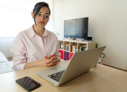 woman video calling using laptop. Businesswoman teleconferencing on laptop while working from home.