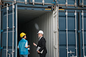 Engineer or foreman checking inside cargo container at a harbor. Logistics concept inside the shipping, import, and export industries.