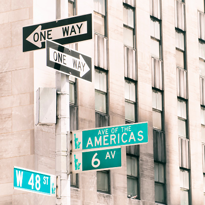 Avenue of the Americas road sign, corner 48st Street, in Midtown Manhattan, NY.