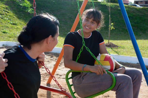 istock teenagers on playground swing 1892448771