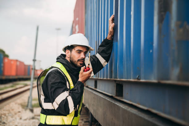 istock Foreman checking inventory or task details on freight train cars and shipping containers. Logistics concept, import, and export industries. 1892467958
