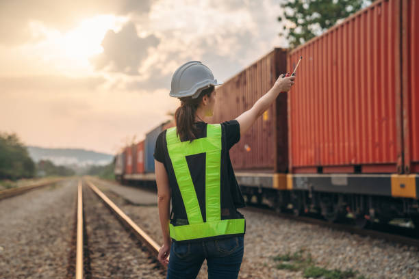 istock Foreman checking inventory or task details on freight train cars and shipping containers. Logistics concept, import, and export industries. 1892470011
