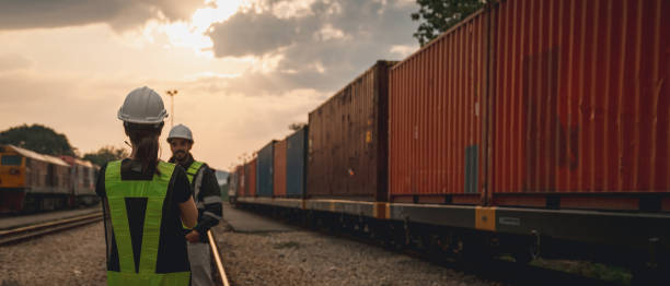 istock Foreman checking inventory or task details on freight train cars and shipping containers. Logistics concept, import, and export industries. 1892470528