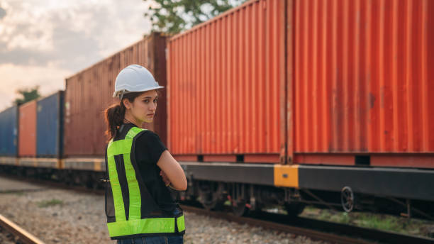 istock Foreman checking inventory or task details on freight train cars and shipping containers. Logistics concept, import, and export industries. 1892471287