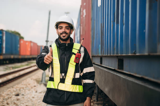 istock Foreman checking inventory or task details on freight train cars and shipping containers. Logistics concept, import, and export industries. 1892474626