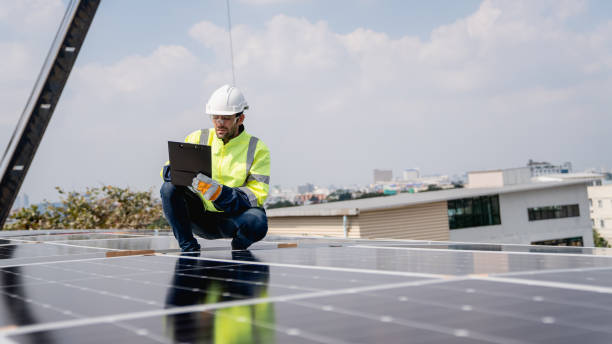 istock Service engineer installing solar cell on the roof of factory. Technicians working about solar panel system outdoors. Clean and Renewable energy concept. 1892539491
