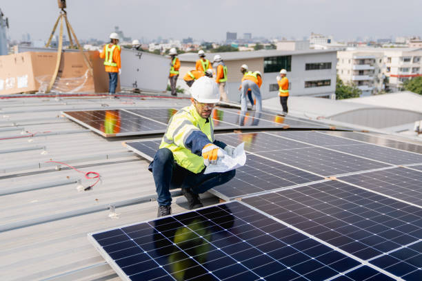 istock Service engineer installing solar cell on the roof of factory. Technicians working about solar panel system outdoors. Clean and Renewable energy concept. 1892540522
