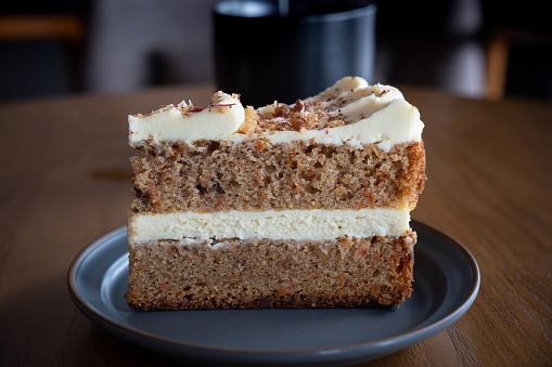 A slice of carrot walnut cake served in a cafe.