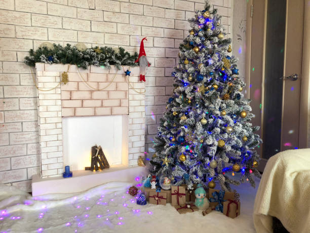 istock Christmas tree with presents and fireplace on the background of a brick wall 1892559987