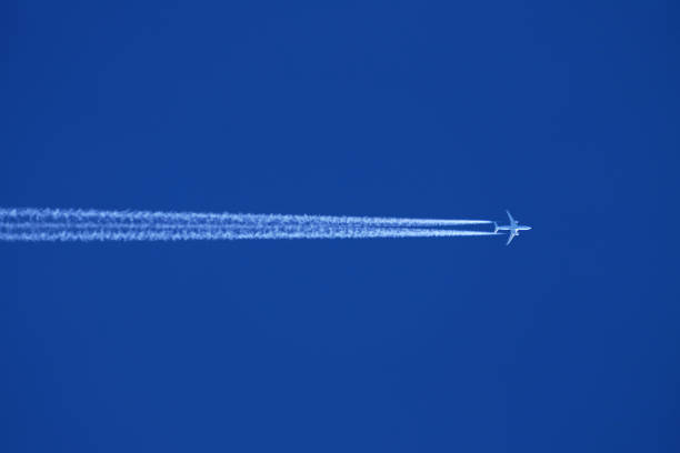 istock Airplane in the blue sky with contrail 1892576865