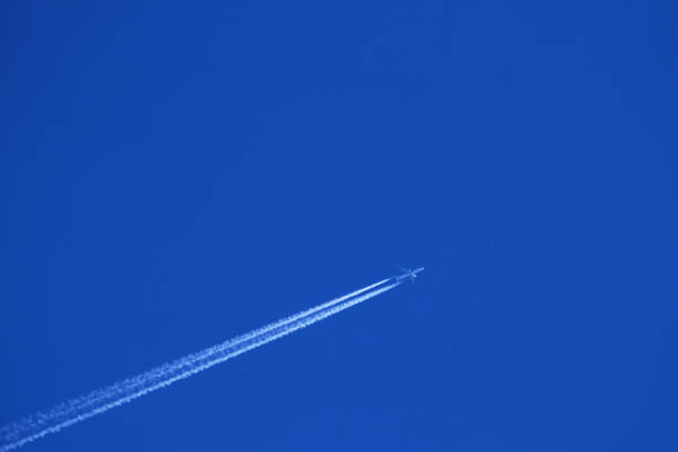 istock Airplane in the blue sky with contrail 1892576875