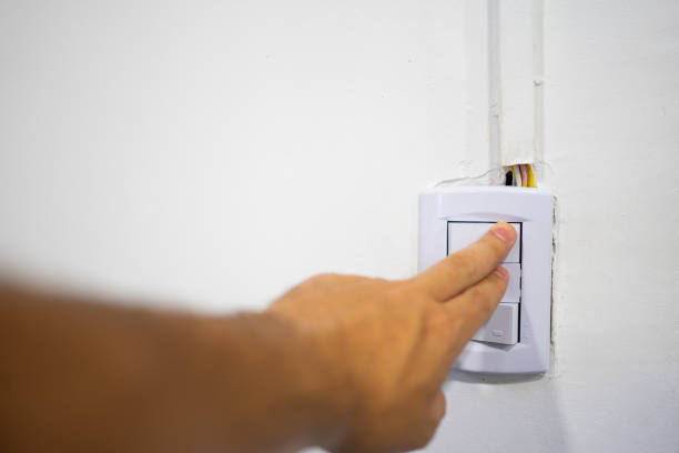 istock A person turning on the light switch. With exposed wires. 1892587229