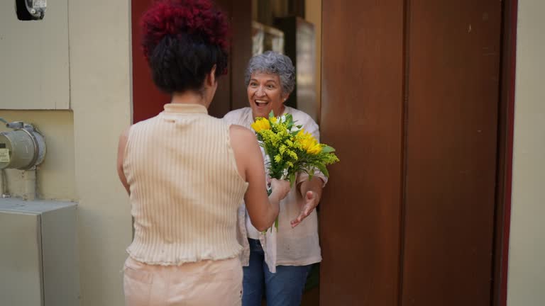 Senior woman being surprised by her granddaughter's visit at home