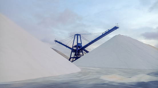 Mountains of sea salt and cranes in the salt mining industry of Torrevieja, Spain