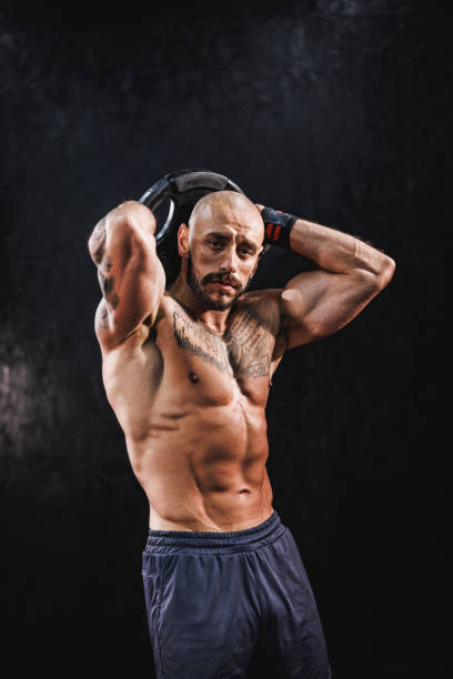 istock Man Exercise With Weights And Showing His Muscles At The Gym 1892694625