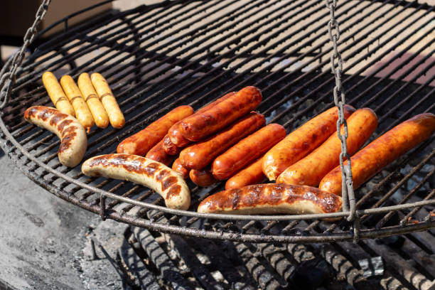 istock Grilled sausages on grill on flame closeup 1892743304