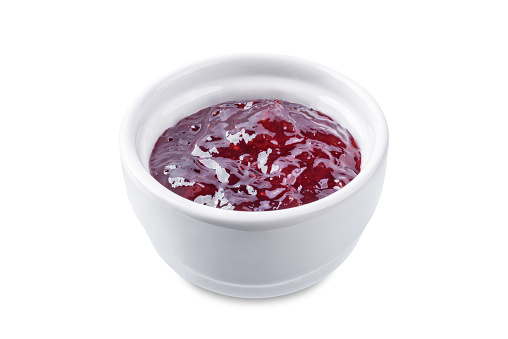 Raspberry sweet confiture in a bowl on a white isolated background. toning