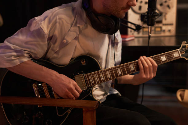 istock Guitarist Recording Semi-Acoustic Guitar in Studio 1892779086