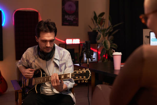 istock Focused Musician Playing Guitar during Podcast 1892779598