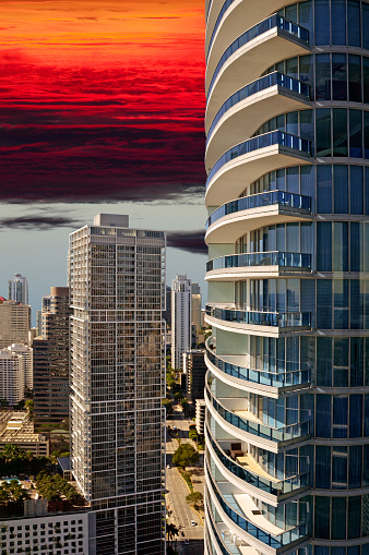 Architecture: Sunrise behind the urban landscape is shown in this view of the Miami skyline looking South from the 40th floor of a building in the center of the city. High rise, luxury office buildings and condominiums paint the landscape.