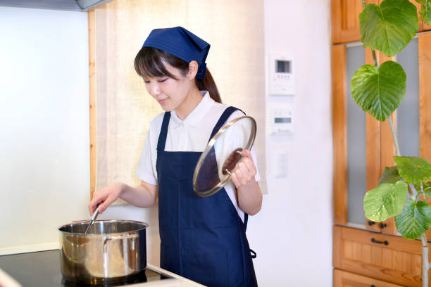 istock Asian female housekeeper cooking in the kitchen 1892808829