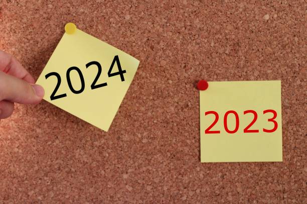 istock a man's hand pulling out a sticky note. year change from 2023 to 2024. 2024 year consept idea. 1892850493