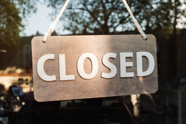istock Store closed sign hanging on the window 1892857213