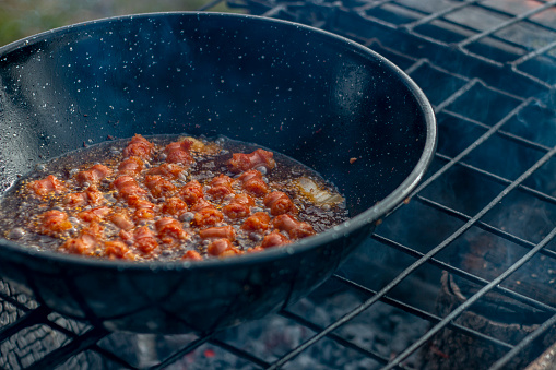 Cooking the typical Spanish dish of Migas Castellanas over a wood fire and you can see the entire process along with its ingredients such as bread, chistorra, peppers, garlic, bacon and occasionally grapes.