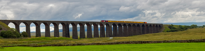 Web banner image of a diesel locomotive crossing on the Ribblehead Railway Viaduct in the Yorkshire Dales National Park, England.
