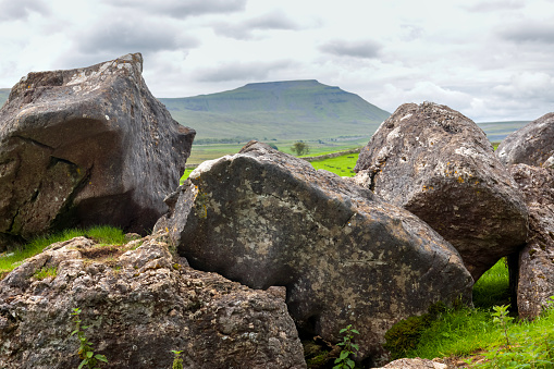 Ingleborough, one of the three peaks challenge hills, seen over limestone rocks in the Yorkshire Dales National Park, England.