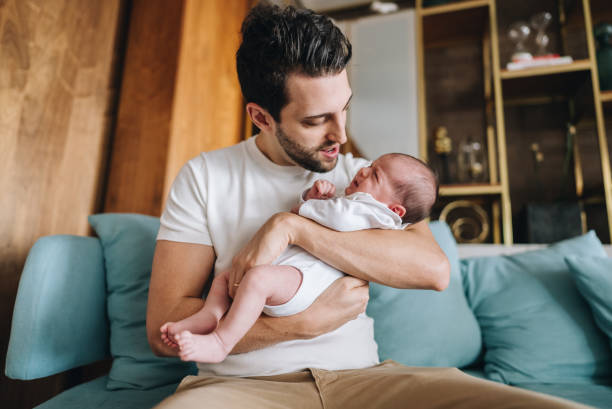 istock Father holding his newborn daughter at home 1892956355