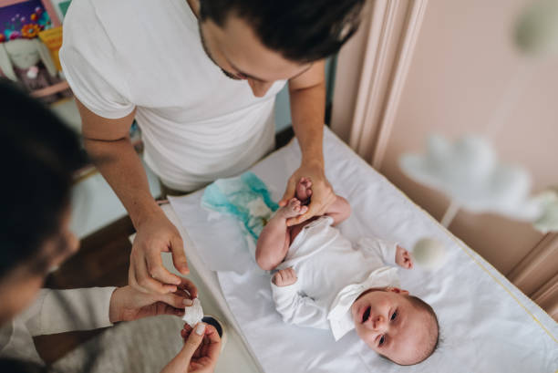 istock Father changing his newborn daughter's diaper at home 1892956757