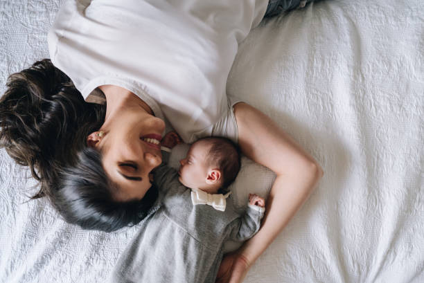 istock Mother looking at her newborn daughter while sleeping in bed at home 1892964148